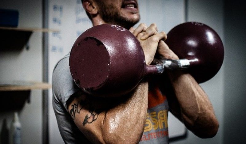 Man lifting kettlebell, Skelian Chiropractic Clinic